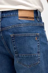 Jean de corte holgado en cadera y cintura con piernas de calce recto, en color azul oscuro con efecto lavado.