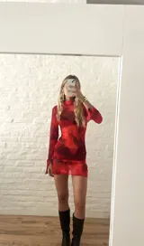 Minivestido rojo de microtul elastizado con estampado abstracto en tonos oscuros. Diseño ajustado con cuello alto y mangas largas.