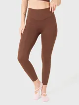 Calza deportiva de tiro alto con largo al tobillo, confeccionada en tejido técnico elástico de color marrón chocolate.