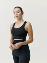 Top deportivo negro de alta sujeción, con tejido Fit_tech con tecnología 3D, juego de texturas y espalda atlética.