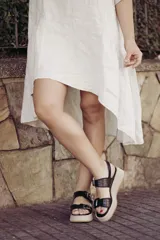 Sandalia de plataforma color beige claro, con dos tiras anchas con estampado de piel de serpiente (pitón) y hebillas metálicas.