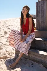 Chaleco corto tejido a mano en crochet, color celeste, con silueta ajustada, sin mangas y lazos en la delantera.