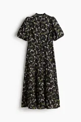 Vestido largo negro con estampado floreado, cuello mao, mangas globo cortas y falda escalonada con volados.