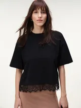 Remera boxy de algodón negro con mangas al codo y bajo recto con detalle de encaje al tono.