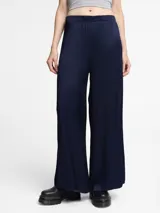 Pantalón de corte ancho y silueta fluida, confeccionado en tejido con textura arrugada y cintura elástica.