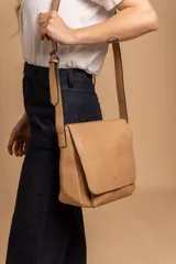 Bandolera de diseño simple con tapa frontal, confeccionada en material símil cuero. Cuenta con correa ajustable, división interna y bolsillos internos para mayor organización.