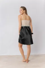 Camisón de satén elastizado color gris claro, con escote recto y detalle de puntilla elastizada en el busto y espalda. Tiene breteles finos regulables y un largo por encima de la rodilla.