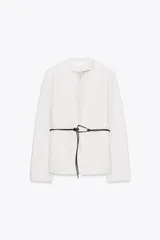 Blazer de textura suave, cuello redondo y manga larga. Presenta un diseño minimalista con cierre frontal mediante un cinturón fino de cuero con hebilla metálica.