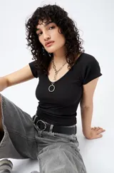 Top negro de tejido acanalado (ribb) con escote en V y mangas cortas con dobladillo. De corte ajustado y largo cropped.