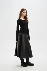 Top de manga larga color negro, confeccionado en poliéster, con diseño drapeado frontal y cuello en V.