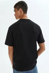 Remera negra de corte relajado, confeccionada con tejido liviano COOLMAX con cuello redondo y mangas cortas.