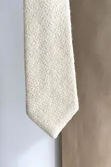 Corbata delgada de lana con forro interno y diseño a cuadros en tonos marrón y beige.