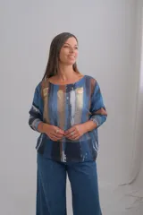 Sweter de punto con diseño abstracto de rayas verticales en tonos azules, marrones y detalles metalizados dorados. Presenta cuello redondo y mangas largas con puños ajustados.