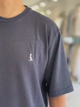 Remera oversize de tejido texturizado en color verde militar, con cuello redondo y mangas cortas. Presenta un pequeño bordado blanco en el pecho.