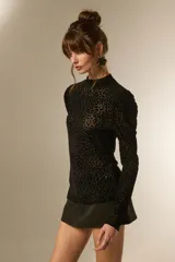 Top de manga larga ajustado al cuerpo, con cuello alto y estampado de leopardo en negro. El tejido es transparente con el patrón en relieve.