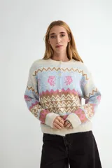 Cardigan de punto con diseño jacquard de patrones geométricos y motivos florales. Presenta cuello redondo, cierre frontal con botones y puños acanalados.