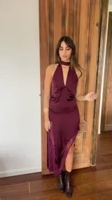 Vestido midi de satén color bordó, con escote halter y detalle de encaje en el ruedo. Presenta un diseño fluido y elegante con abertura lateral.
