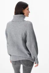 Sweater de punto con textura acanalada, cuello alto tipo polerón, mangas largas con diseño abuchonado y puños anchos.