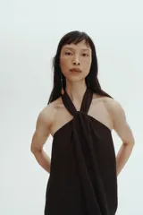 Vestido midi negro confeccionado en punto con efecto arrugado, de escote halter alto con detalle girado y tiras anchas con diseño solapado al frente.