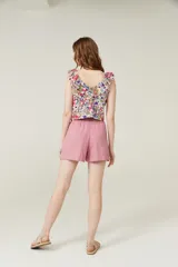 Blusa cropped con estampado multicolor, cuello redondo, sin mangas y volados en los hombros.