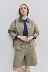 Campera de gabardina tostada, con cuello camisero de pana marrón, cierre frontal de botones metálicos y bolsillos delanteros aplicados con solapa.