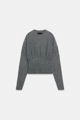 Jersey de punto color gris, con cuello redondo, manga larga y detalle de cintura ajustada con tejido tipo nido de abeja.