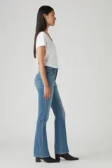 Jean azul de tiro alto, corte bootcut, con lavado medio y efecto desgastado en los muslos.