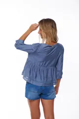 Blusa celeste con escote cuadrado, mangas 3/4 abullonadas y detalle de puntilla en escote y mangas.