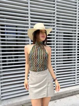 Minifalda gris cruzada de gamuza sintética, con hilera de ojales metálicos en la cintura.