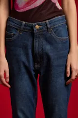 Pantalón jean negro de tiro medio y corte flare, con bolsillos laterales y traseros.