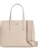 Cartera tipo tote de Calvin Klein, color beige claro, con textura de monograma en relieve. Posee doble asa de mano y una correa ajustable y extraíble de tela.