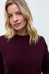 Sweater de punto color ciruela, con cuello redondo, mangas 3/4 y corte holgado.