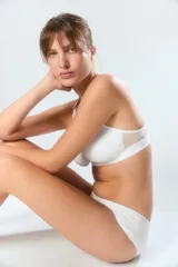 Soutien deportivo de algodón color beige, con diseño sin aro, breteles regulables y banda elástica inferior con logo de la marca.