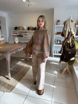 Blusa de manga larga con diseño de cuadros en tonos camel y azul, confeccionada con tejido elástico fruncido en todo el cuerpo y las mangas.