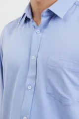 Camisa de vestir para hombre, color azul claro, de manga larga y cuello italiano. Tejido texturado y suave, confeccionada en una mezcla de algodón y poliéster.