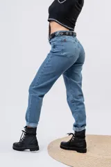 Jeans mom fit de tiro alto y lavado azul medio, con pernera relajada y dobladillo vuelto en los tobillos.