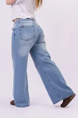 Pantalón wide leg de denim rígido, de tiro bajo en color celeste claro con sutiles desgastes, pernera ultra ancha y diseño de cinco bolsillos.