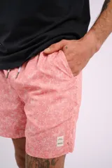 Short de baño color salmón con estampado de estrellas de mar blancas, cordón ajustable en la cintura y bolsillos laterales.