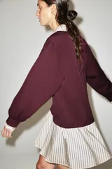 Vestido corto combinado en color bordó y crudo a rayas, con cuello solapa, cierre frontal con cremallera y mangas largas con puños.