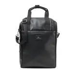 Bolso matero de diseño vertical en color negro, confeccionado en material texturizado símil cuero. Cuenta con doble asa superior, correa ajustable y extraíble para llevar al hombro, y cierre principal. Incluye un aplique metálico con el logo de la marca en el frente.