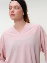 Remera deportiva de manga corta rosada, con escote en V y corte oversized de tejido dry fit.