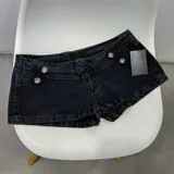 Short de denim negro de tiro bajo, con diseño de doble botonadura metálica decorativa en el frente.