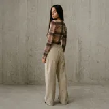Pantalón de pana marrón claro, de corte ancho y recto, con pinzas en la cintura y bolsillos laterales.