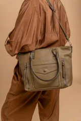 Cartera tipo tote de diseño estructurado en símil cuero, con doble asa rígida y correa regulable. Presenta múltiples bolsillos frontales con cierre y solapa, ofreciendo un estilo versátil y espacioso.