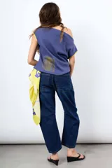 Jean de denim azul de tiro medio, con calce relajado, efecto balloon y costuras frontales. Cuenta con bolsillos traseros y etiqueta de cuero sintético con marca grabada en la parte posterior.