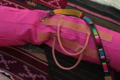 Bolso taquera de gran tamaño, de color fucsia, con cuerpo flexible, asas cortas de cuero y detalles en contraste. Incluye una correa regulable y desmontable estampada y cierre superior con cremallera.
