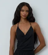 Blusa de chiffon negro, modelo frente única con escote traspasado, sin mangas y caída fluida.