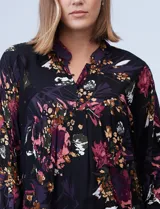 Blusa negra con estampado floral en tonos borgoña, rosa y blanco. Tiene cuello a la base con escote en V y botones.