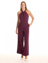 Enterito largo de crepe color ciruela, con escote halter anudado y pierna ancha. Presenta bolsillos laterales y abertura en la espalda con cierre invisible.