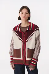 Cardigan de punto con diseño multicolor, cuello tipo polo con rayas, cierre frontal con botones y bolsillos aplicados. Presenta mangas con trama trenzada, coderas en contraste y bordado de la marca en el frente.